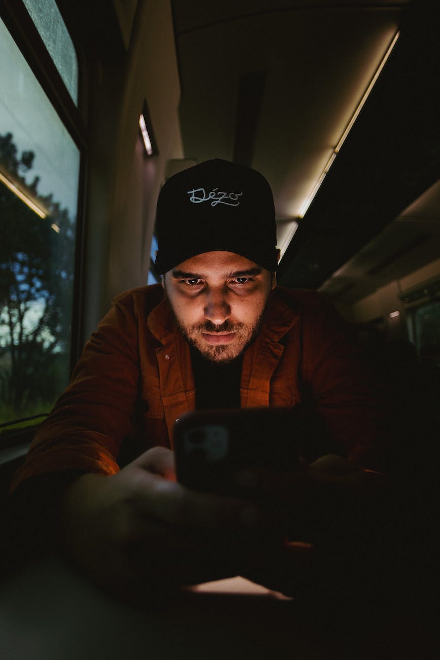 man using cellphone in dark train