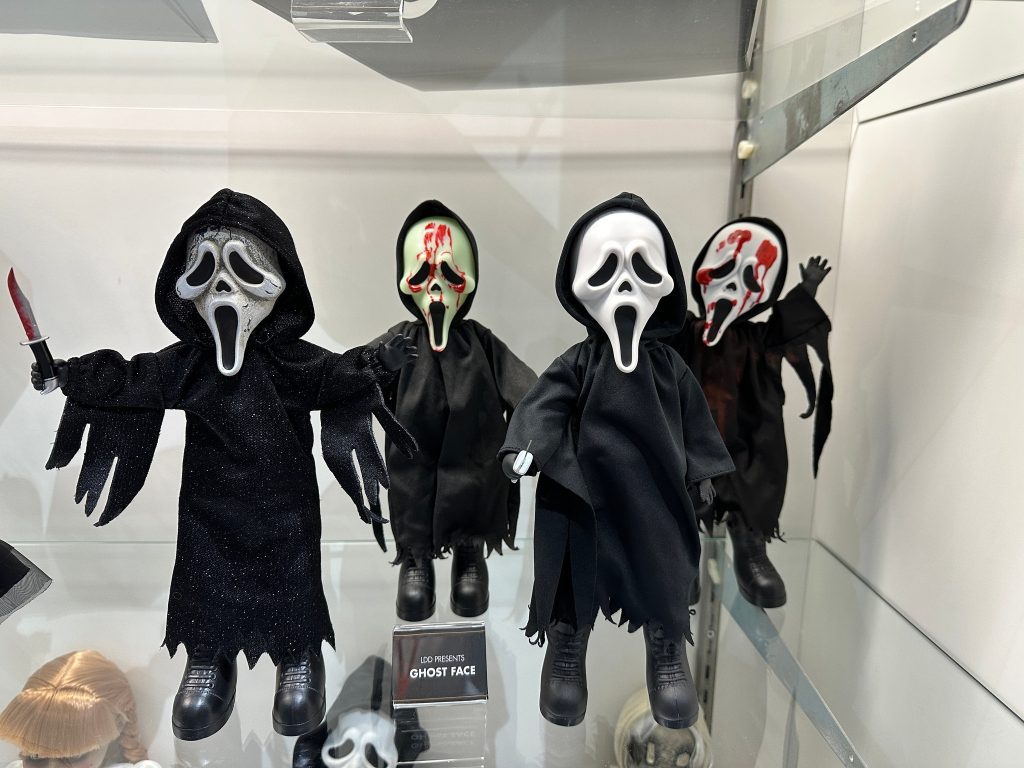 A Ghostface toy from Scream holding a knife, based on the look of the character in the 2022 Scream movie. This exclusive toy was released at San Diego Comic Con 2023 and features a black robe with white ghost mask and red accents.